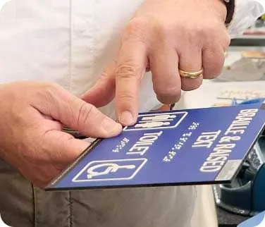 Blaues Schild mit herausragenden Buchstaben sowie